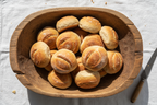 Rustic Wooden Dough Bowl with bread rolls